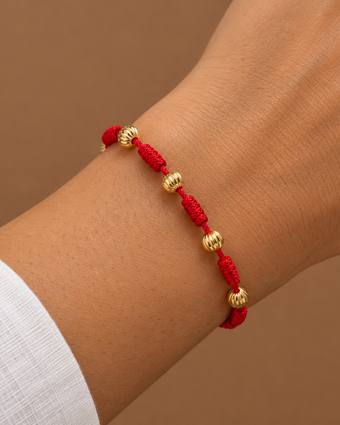 Pulsera 7 nudos roja con oro corrugado, puesta