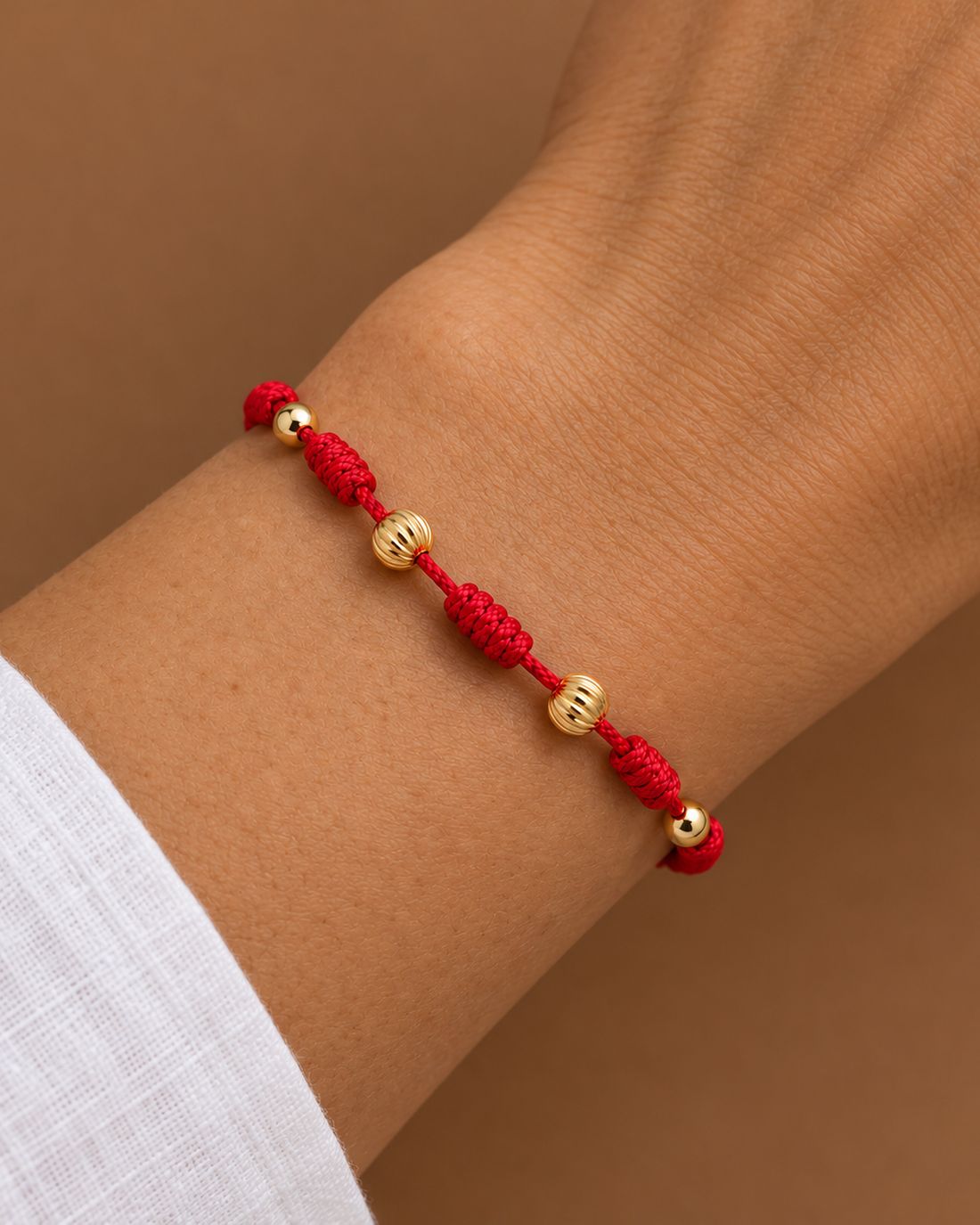 Pulsera 7 nudos roja mixta, puesta en la muñeca