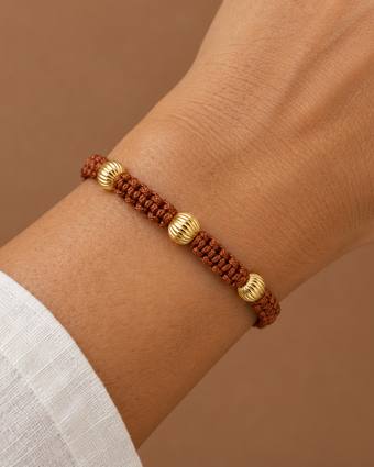 Pulsera tejida café con oro corrugado, puesta