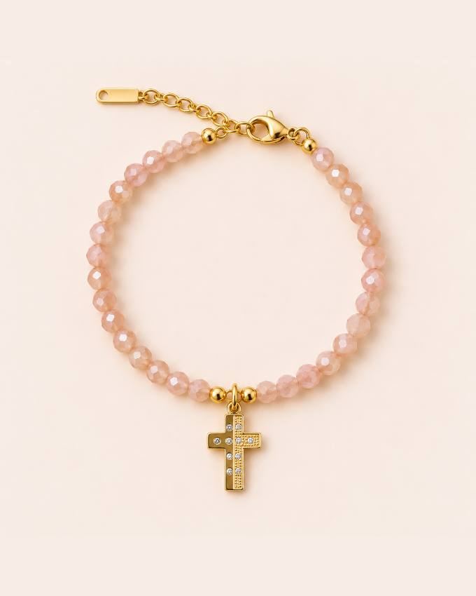 Pulsera rosa con cruz dorada