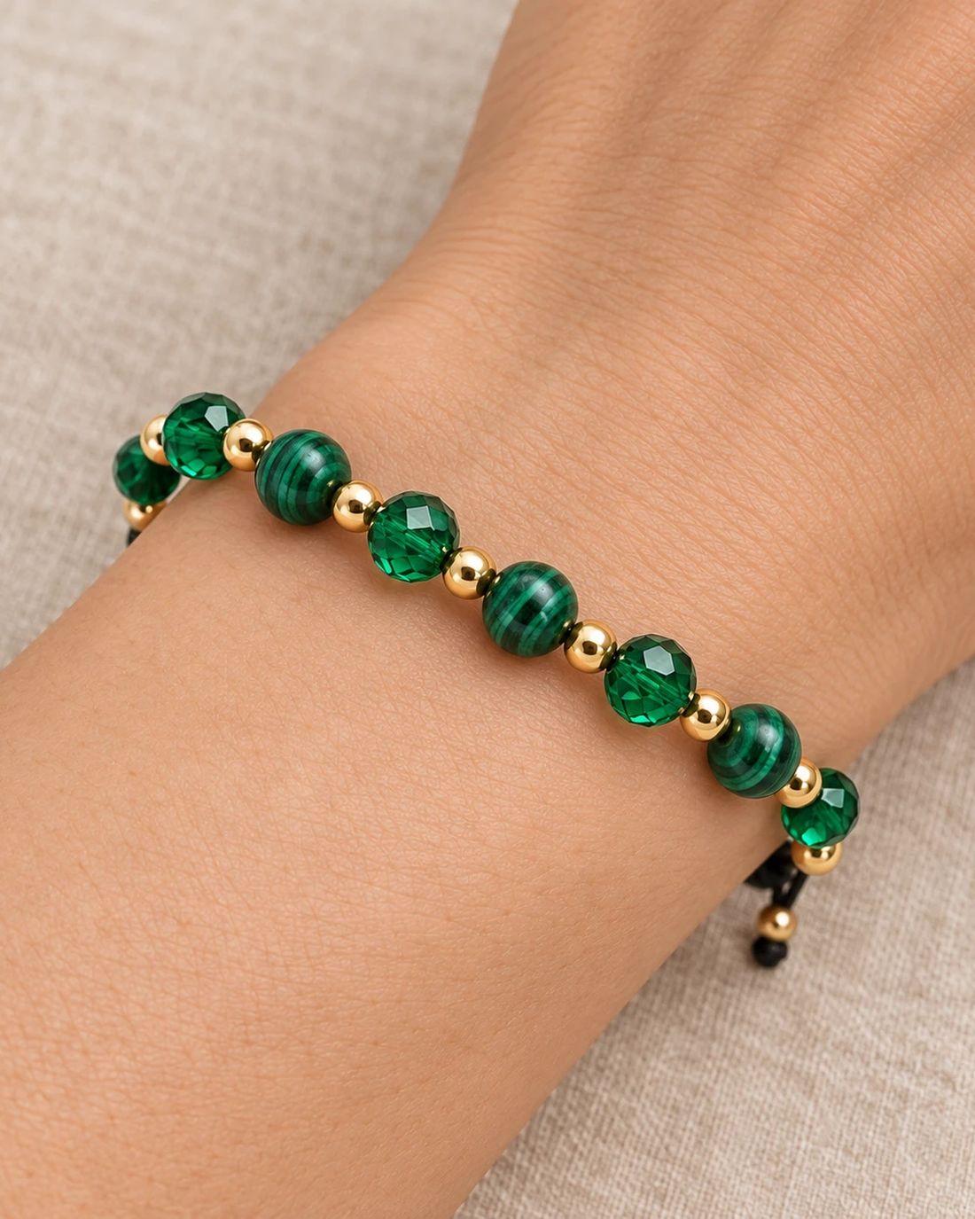 Pulsera de cristal verde esmeralda, puesta en la muñeca
